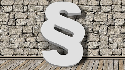 Paragraphensymbol vor Pflastersteinmauer